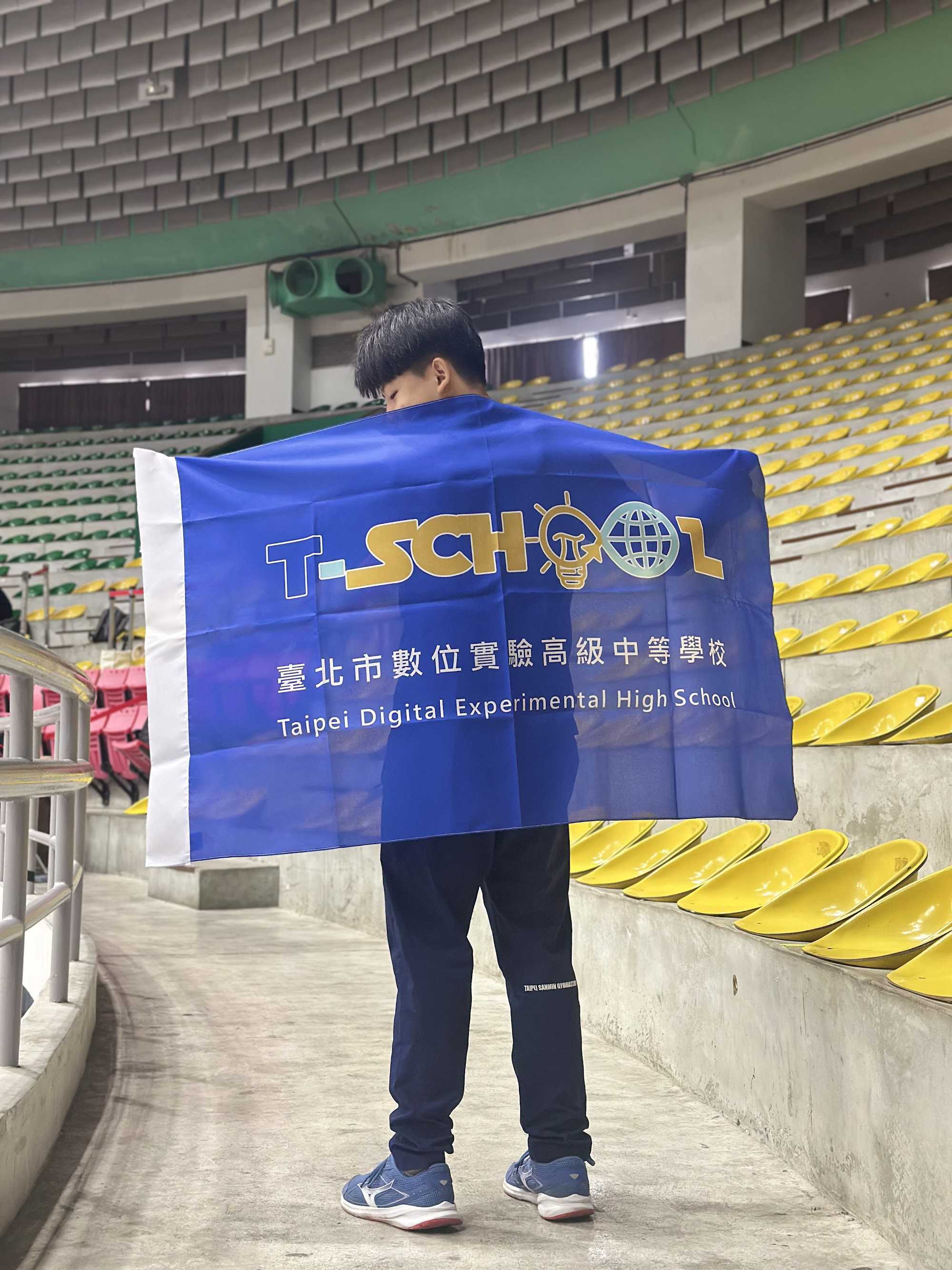 曾翌瑋同學參加113年全國競技體操錦標賽時披著校旗的相片